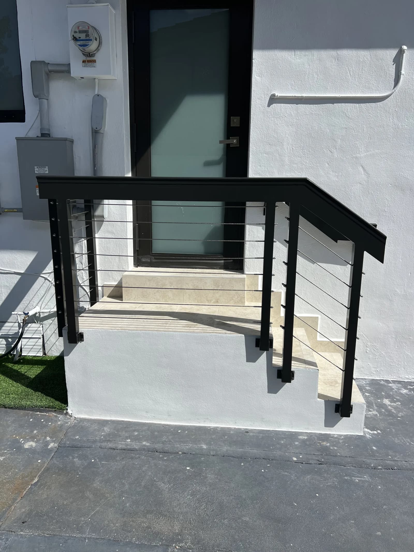 Black aluminum railing on white entrance steps